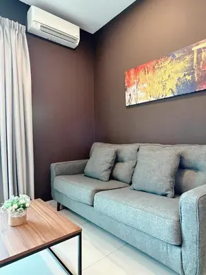 a living room with a couch and a fan at Sunway Onsen Suite Cozy Homestay in Ipoh
