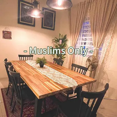 a wooden dining room table with chairs around it at Inang Homestay in Teluk Intan