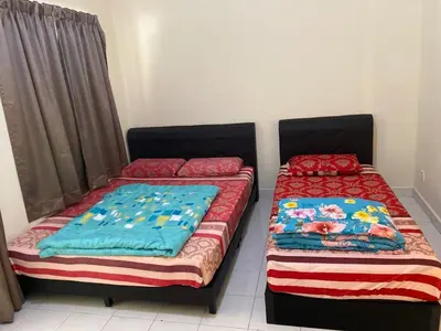 two beds sitting next to each other in a room at Highlands Double Story House in Tanah Rata