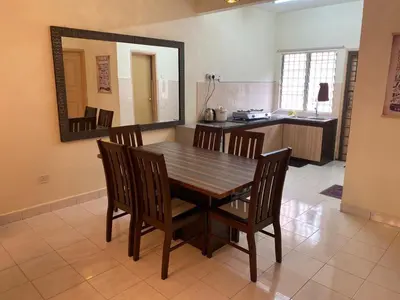 a dining room table with chairs and a mirror at Highlands Double Story House in Tanah Rata