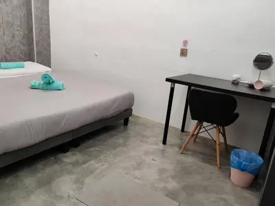 a room with a bed and a desk with a chair at Triple Room in King Queen Single Bukit Mertajam Alma in Bukit Mertajam