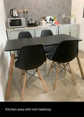 a kitchen area with a black table and two chairs at Triple Room in King Queen Single Bukit Mertajam Alma in Bukit Mertajam