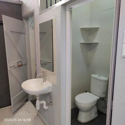a small bathroom with a toilet and a sink at Sterling Homestay in Tanjung Bungah