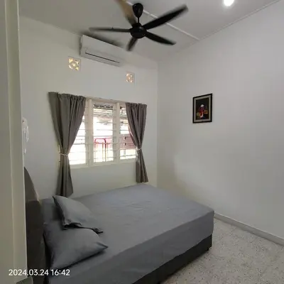 a bedroom with a bed and a ceiling fan at Sterling Homestay in Tanjung Bungah