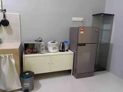 a small kitchen with a refrigerator and a counter at Bota TheDaun Homestay Taman Indera in Kampung Bota Kiri