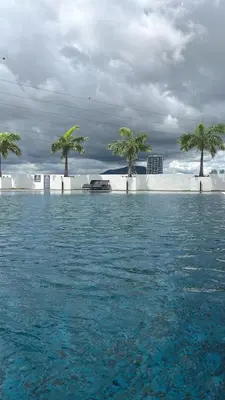 a pool of water with palm trees in the background at Meritus Family Comfy Deluxe Home in Perai