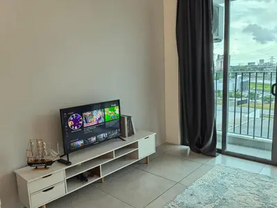 a living room with a flat screen tv on a white cabinet at Meritus Family Comfy Deluxe Home in Perai