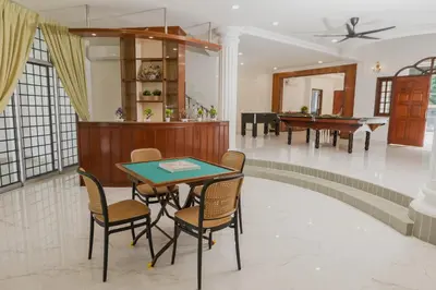 a dining room with a table and chairs and a piano at Villa55 w Private swimming pool BBQ Pool table 25pax in Bayan Lepas