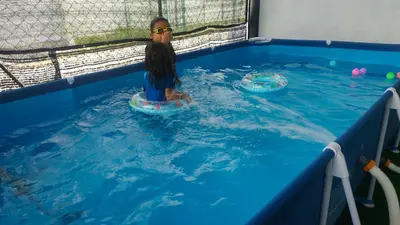 a child in the water in a swimming pool at Homestay Adleya in Bagan Serai