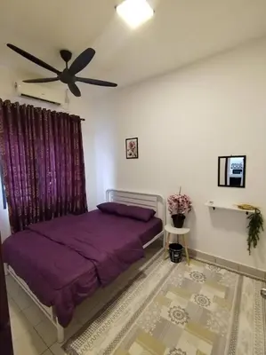 a bedroom with a purple bed and a ceiling fan at Orked Homestay Seri Iskandar in Seri Iskandar