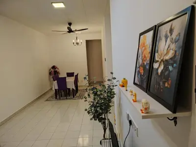 a hallway with a living room with paintings on the wall at Orked Homestay Seri Iskandar in Seri Iskandar