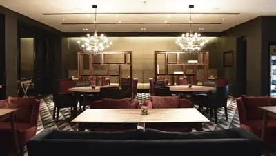 a restaurant with tables and chairs and chandeliers at G Hotel Kelawai in George Town
