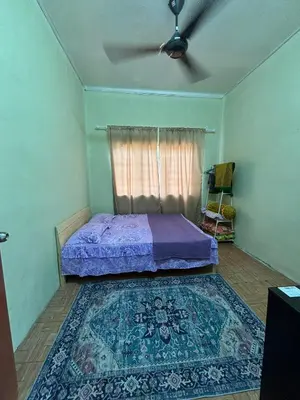 a bedroom with a bed and a ceiling fan at Homestay Abah At in Baling