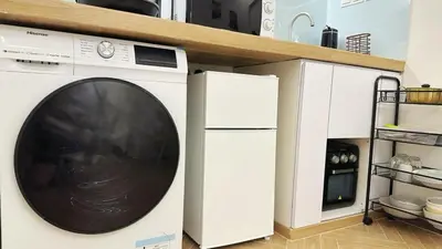 a washing machine in a kitchen next to a refrigerator at Noordin ClanJetties Komtar Heritage Studio - W in George Town