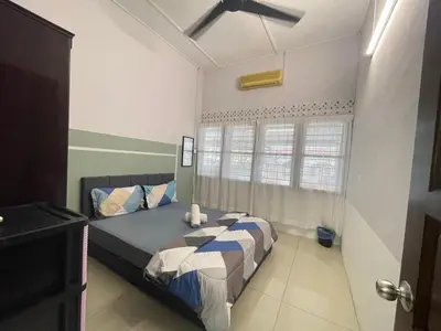 a bedroom with two beds and a ceiling fan at 3 rooms Town Homestay 1 mins to Town in Teluk Intan