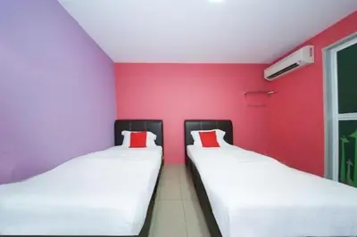 two beds in a room with red and purple walls at The Inn Hotel in Teluk Intan