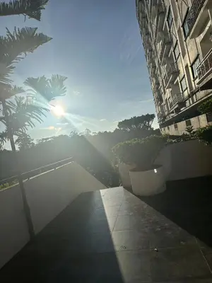 a view of a building with trees and the sun at Nova \u5bb6\u5ead\u623f in Brinchang