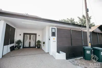 a house with a garage with a door and two plants at Ipoh Cozy 27 Pool Villa 6B5B 30 pax by Verve in Ipoh