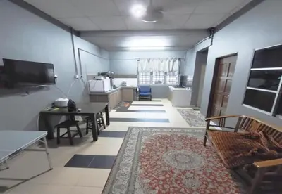 a living room with a couch and a table and a kitchen at Hotel Iskandar Perak in Seri Iskandar