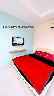 a bedroom with a red bed and a flat screen tv at D'Marina 2 HOMESTAY LUMUT MANJUNG in Lumut