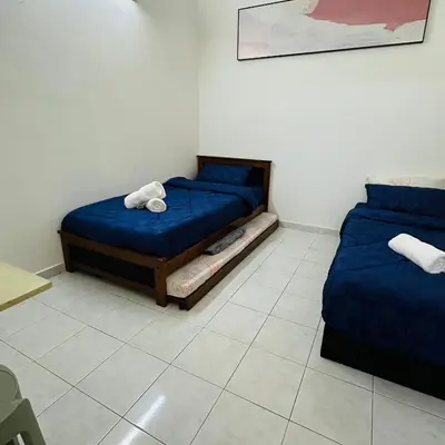 two beds in a room with blue sheets and towels at MayiiVip Homestay - Menglembu in Ipoh