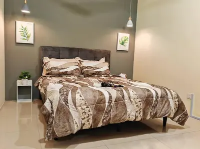 a bedroom with a bed with a blanket and pillows at 20-24Paxx Near Sunway Lst World wPool Tab Karaok in Ipoh