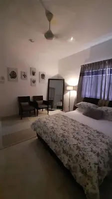 a bedroom with a bed and a chair and a couch at Cozy House in Taiping in Taiping