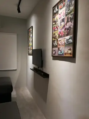 a room with a tv and a picture on the wall at Check-Inn Guesthouse in Ipoh
