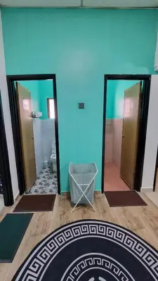 a bathroom with two mirrors and a blue wall at MAR Homestay Seri Iskandar in Seri Iskandar
