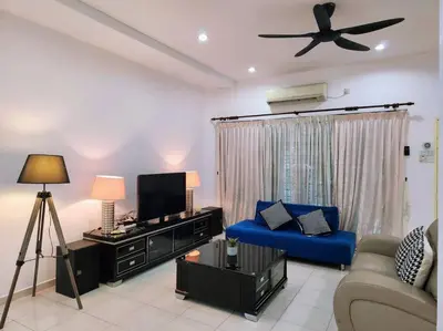a living room with a tv and a blue couch at 10min to IPOH town GEMILANG TAWAS 4br4bath 14pax in Ipoh
