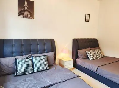a bedroom with two beds and a night stand with a lamp at 10min to IPOH TOWN gunung lang 4br4bath 14 pax in Ipoh