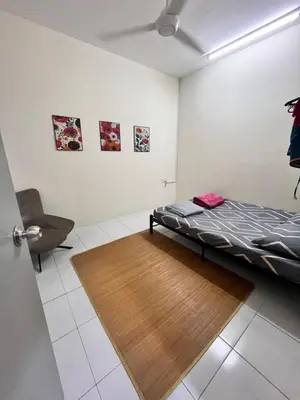 a bedroom with a bed and a chair in it at Mama Zan Homestay in Seri Iskandar