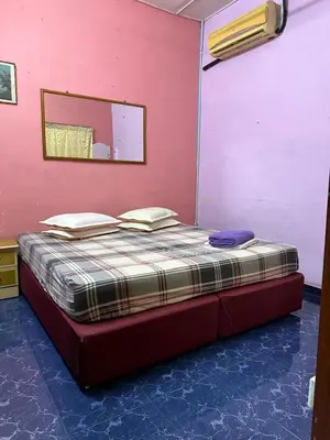 a bed in a room with a pink wall at HOMESTAY Sg Petani in Sungai Petani