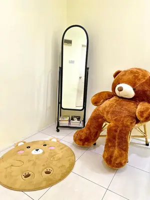 a large teddy bear sitting on a chair next to a mirror at Lovely Homestay in Gerik with Free Netflix & WiFi in Gerik