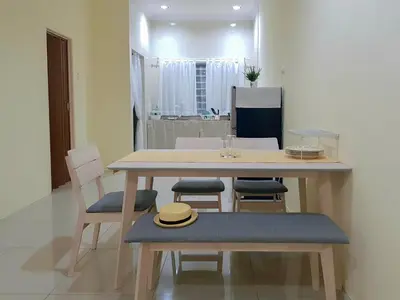 a dining room table with chairs and a hat on it at Lovely Homestay in Gerik with Free Netflix & WiFi in Gerik