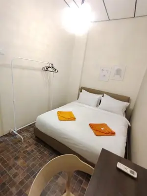 a small bedroom with a bed and a table at Georgetown Cozy 7 Bedrooms 13 Pax in George Town