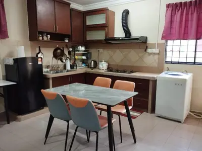a kitchen with a table and chairs and a refrigerator at Homestay Amin 4 Fully Aircond Bedroom & 2 Bathroom in Kulim