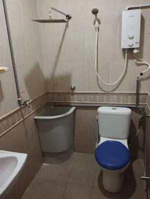 a bathroom with a toilet with a blue seat at Homestay Amin 4 Fully Aircond Bedroom & 2 Bathroom in Kulim