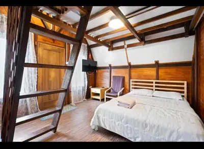 a bedroom with a large bed and a ladder at Hillside cottage tulip room with loteng in Tanah Rata