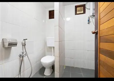 a bathroom with a toilet and a shower at Hillside cottage reflesia room in Tanah Rata