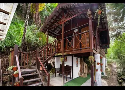 a tree house with a staircase leading up to it at Hillside cottage reflesia room in Tanah Rata