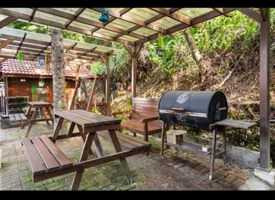 a grill and a picnic table under a pergola at Hillside cottage reflesia room in Tanah Rata