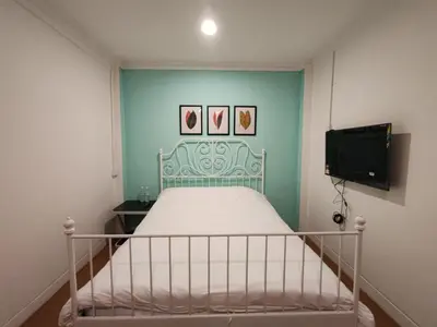a small bedroom with a bed and a tv at Songtam Hotel in Ipoh