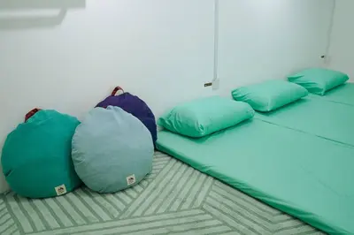 two beds in a room with blue pillows at Cozy Homestay at Tanah Rata - Moonshot Highlanders in Tanah Rata