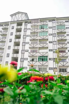 a large white building with flowers in front of it at Cozy Homestay at Tanah Rata - Moonshot Highlanders in Tanah Rata