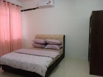 a bedroom with a bed with purple pillows on it at Suriati&Fhaiz Homestay in Sungai Petani