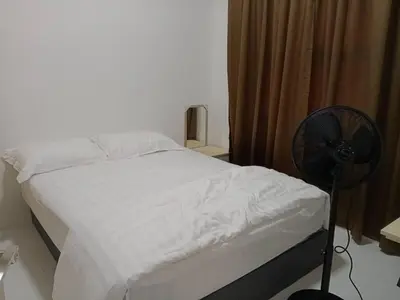 a bedroom with a white bed with a fan at Soho LESTARI in Seri Iskandar