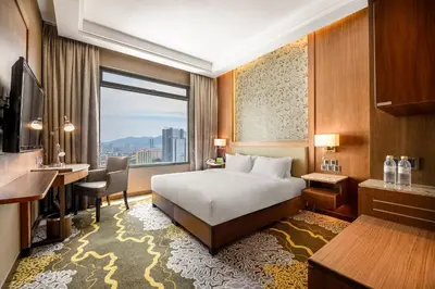 a hotel room with a bed and a desk and a window at St Giles Wembley Penang in George Town
