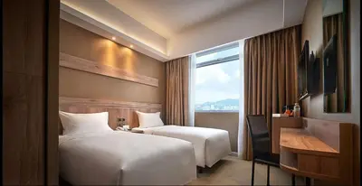 a hotel room with two beds and a window at Cititel Express Penang in George Town