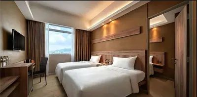a hotel room with two beds and a desk at Cititel Express Penang in George Town